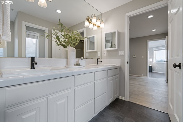 full bath with a chandelier, recessed lighting, double vanity, and a sink