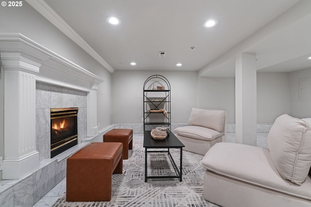 living room featuring a high end fireplace, visible vents, decorative columns, ornamental molding, and recessed lighting