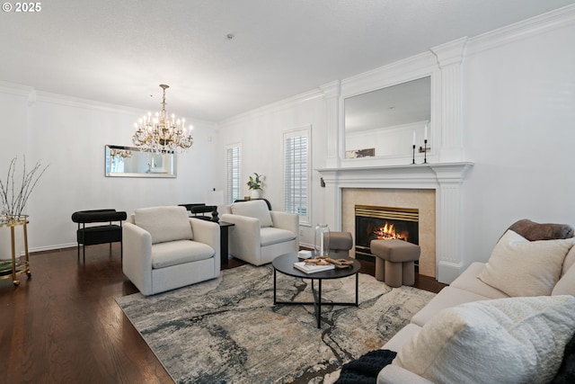 living area featuring dark wood-type flooring, crown molding, a notable chandelier, and a fireplace