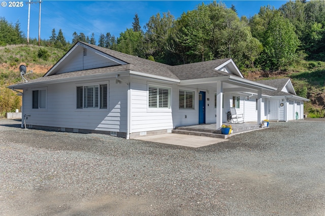 view of front of property with covered porch, crawl space, and a shingled roof