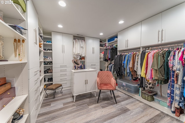 walk in closet with light wood-style floors