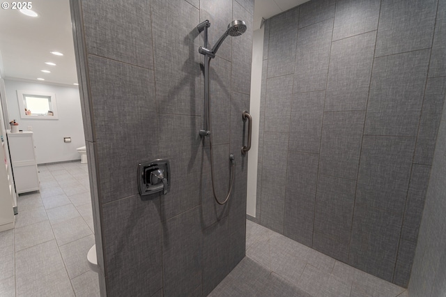 bathroom with toilet, a tile shower, tile patterned flooring, and recessed lighting