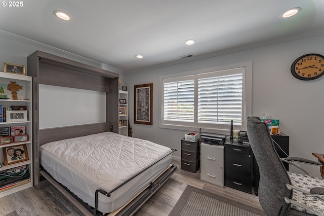 bedroom with crown molding, an office area, recessed lighting, and light wood-style floors