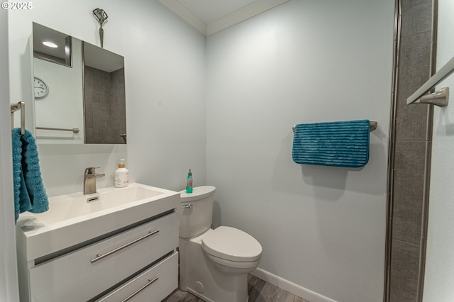 bathroom with wood finished floors, toilet, vanity, and baseboards