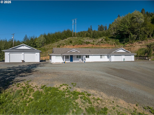 view of front of house with a garage, an outdoor structure, and covered porch