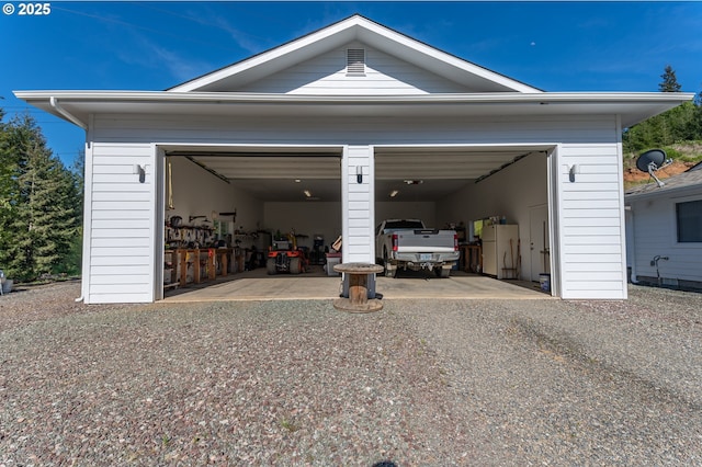 garage featuring freestanding refrigerator and driveway