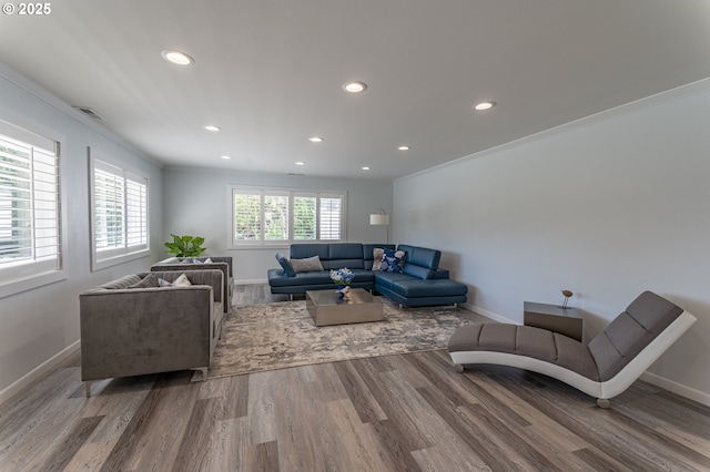 living area featuring recessed lighting, wood finished floors, baseboards, and crown molding