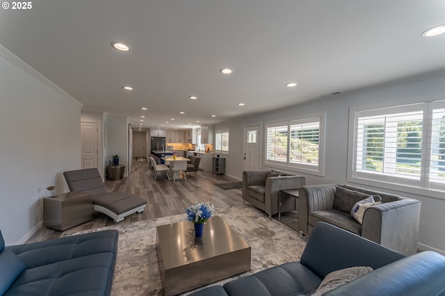 living room featuring wood finished floors, recessed lighting, baseboards, and ornamental molding