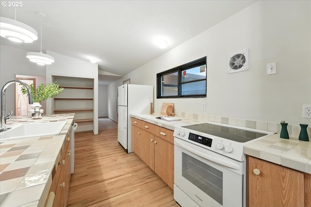 80487 Sha Ne Mah Rd, Seaside, OR 97138 - kitchen featuring white appliances, tile countertops, light wood-style floors, vaulted ceiling, and brown cabinetry
