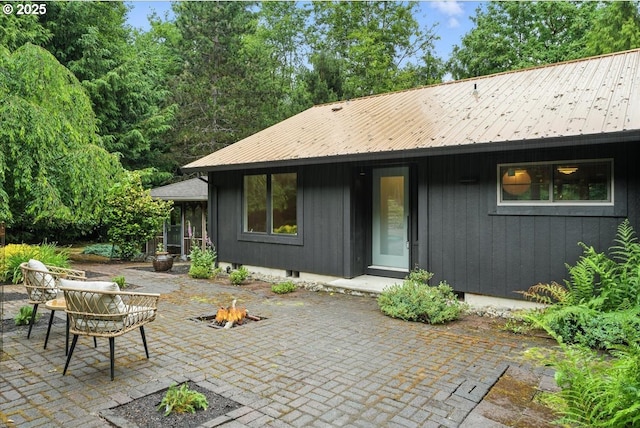 80487 Sha Ne Mah Rd, Seaside, OR 97138 - rear view of house with a patio area, a metal roof, and a fire pit