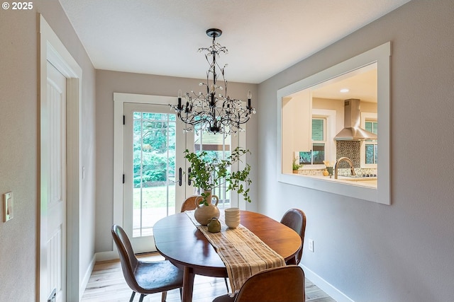 dining room with a chandelier, wood finished floors, and baseboards