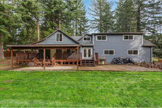 rear view of property featuring a patio, a yard, a shingled roof, and a wooden deck