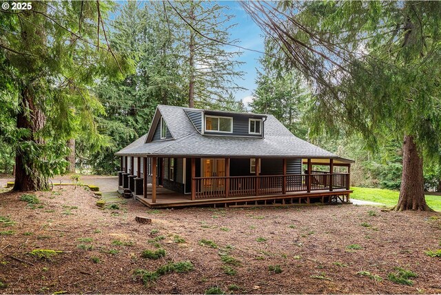 rear view of property with a porch and roof with shingles