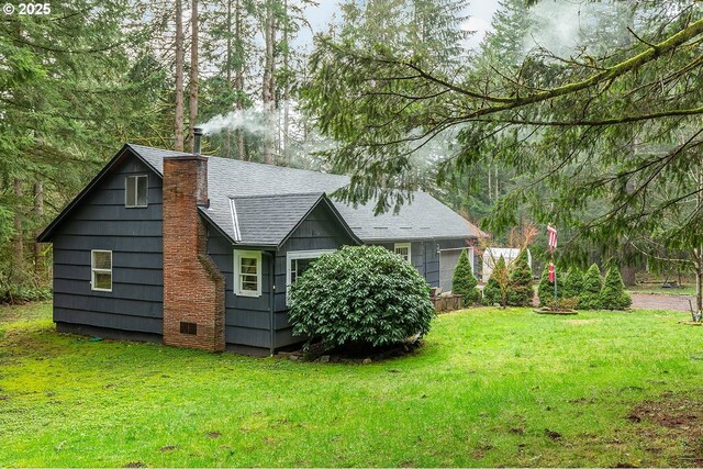 view of home's exterior featuring a shingled roof, a yard, and a chimney