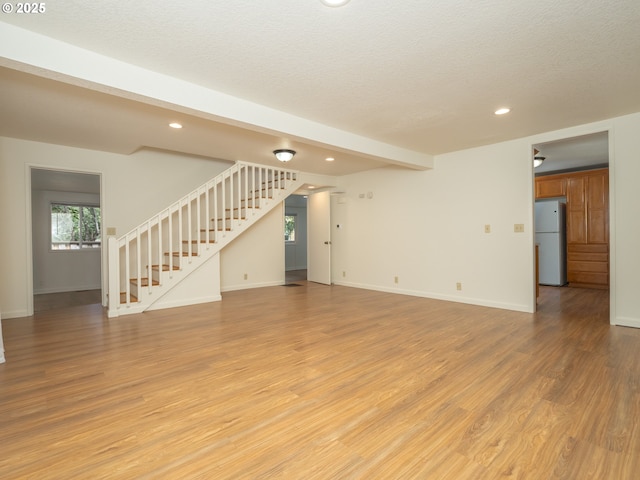 3511 SW Coronado St, Portland, OR 97219 - unfurnished living room with stairway, light wood-type flooring, recessed lighting, and a textured ceiling