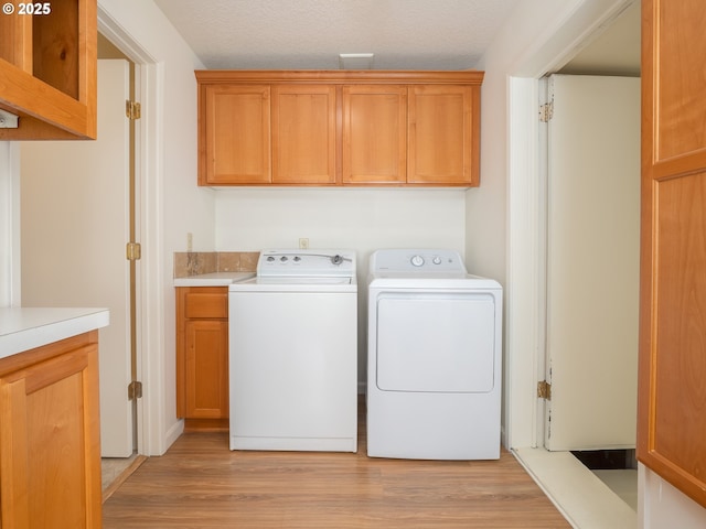 3511 SW Coronado St, Portland, OR 97219 - laundry area with cabinet space, independent washer and dryer, and light wood finished floors