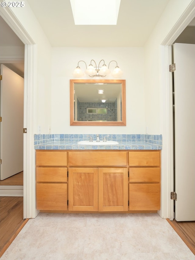 3511 SW Coronado St, Portland, OR 97219 - bathroom featuring a skylight, vanity, and wood finished floors