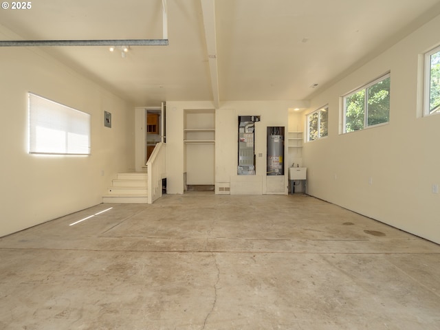 3511 SW Coronado St, Portland, OR 97219 - unfurnished living room featuring water heater, unfinished concrete floors, heating unit, and stairs