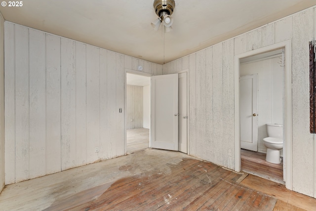 206 NE Laurel Ave, Myrtle Creek, OR 97457 - unfurnished bedroom featuring hardwood / wood-style floors, ensuite bath, wooden walls, and a ceiling fan