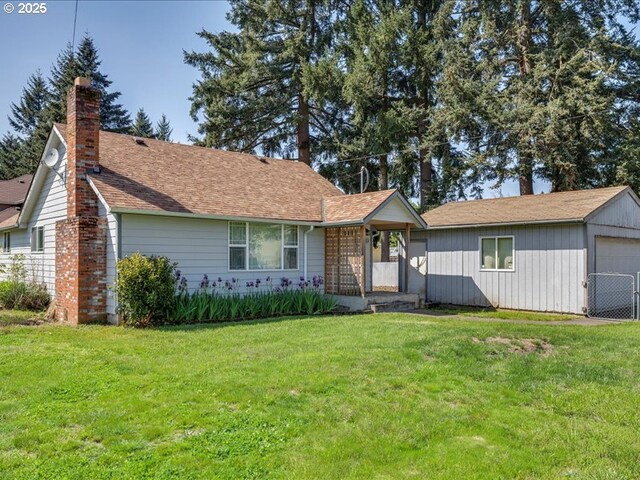 ranch-style house featuring a chimney, a garage, a front yard, and a shingled roof