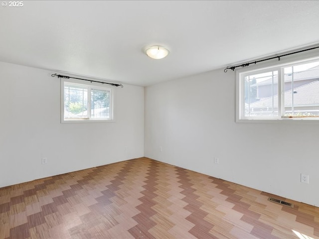 spare room with light wood finished floors and visible vents