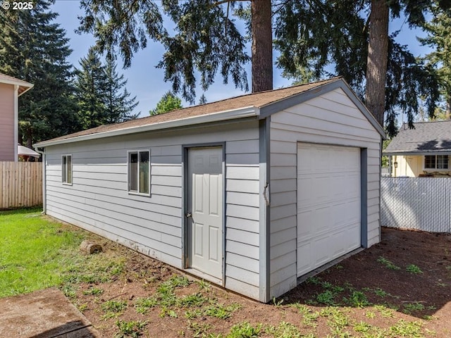 detached garage featuring fence