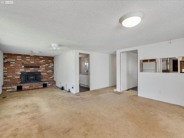 unfurnished living room with carpet floors, a textured ceiling, and visible vents