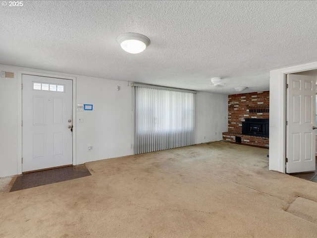 unfurnished living room with carpet floors, a textured ceiling, and a fireplace