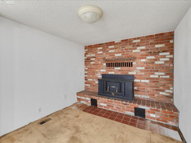unfurnished living room with carpet floors, a textured ceiling, and visible vents