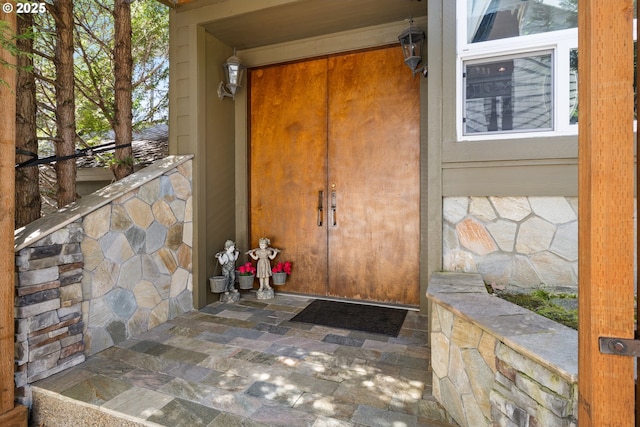 doorway to property with stone siding