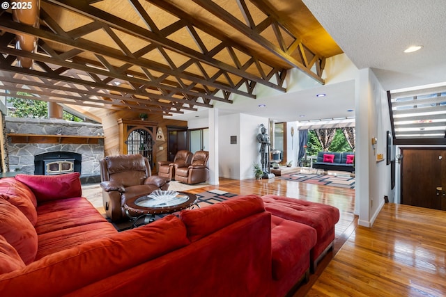 living area featuring high vaulted ceiling, wood finished floors, plenty of natural light, baseboards, and recessed lighting
