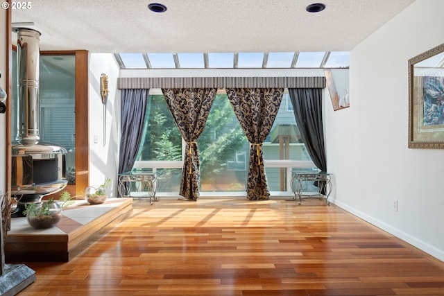 spare room featuring a textured ceiling, wood finished floors, and baseboards