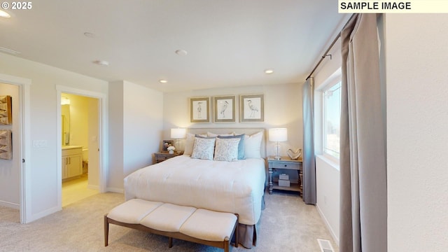 bedroom featuring connected bathroom and light colored carpet