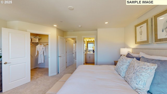 carpeted bedroom featuring ensuite bath, a walk in closet, and a closet