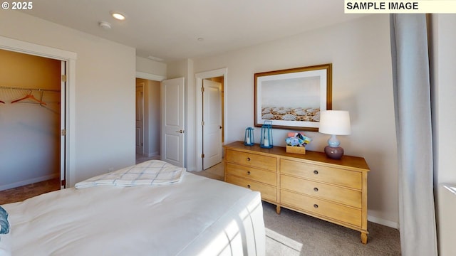 carpeted bedroom with a walk in closet