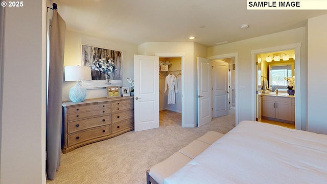 carpeted bedroom featuring a spacious closet, ensuite bath, and a closet