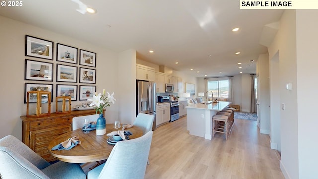 dining area with sink and light hardwood / wood-style flooring