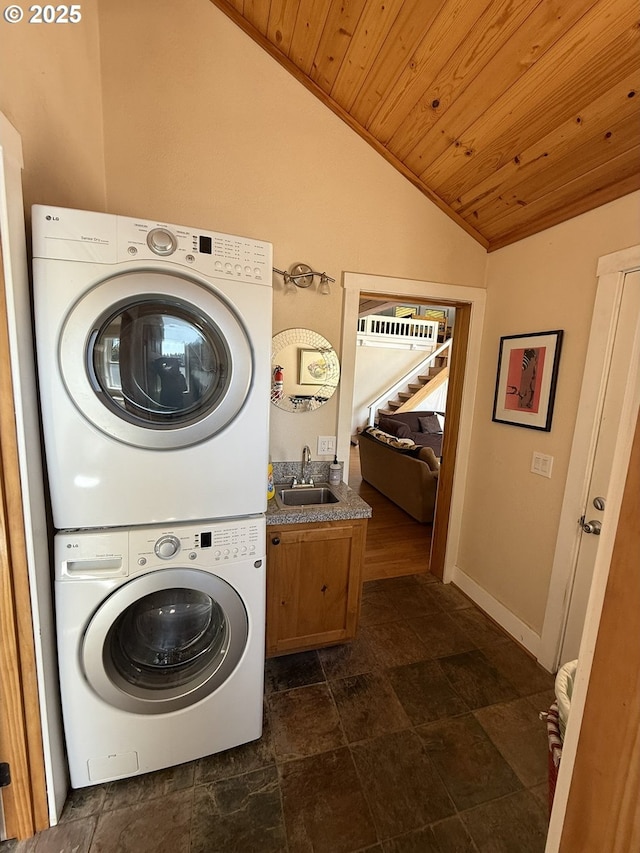 3140 S Tenmile, Lakeside, OR 97449 - laundry room featuring wooden ceiling, a sink, stone finish flooring, cabinet space, and stacked washer and dryer