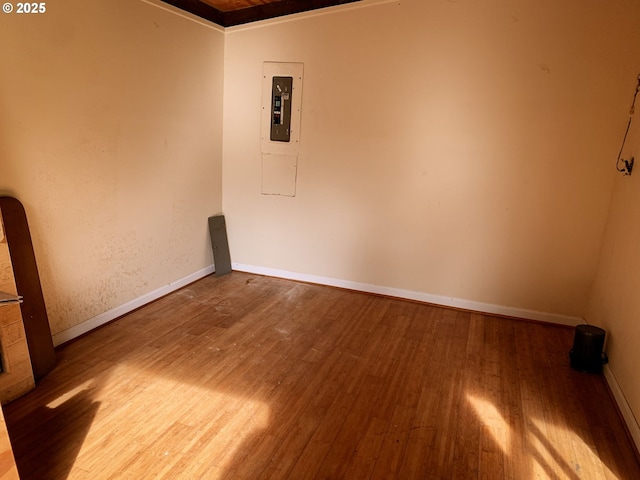 spare room featuring electric panel and wood-type flooring