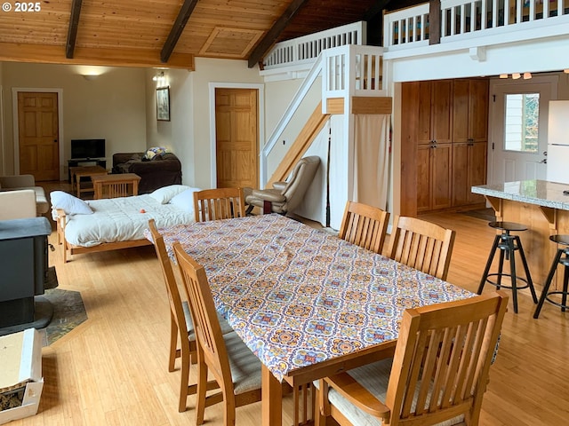 dining space with light hardwood / wood-style flooring, lofted ceiling with beams, and wood ceiling