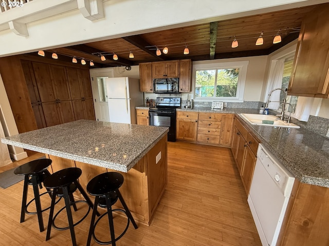 3140 S Tenmile, Lakeside, OR 97449 - kitchen with light wood finished floors, beam ceiling, a sink, and black appliances
