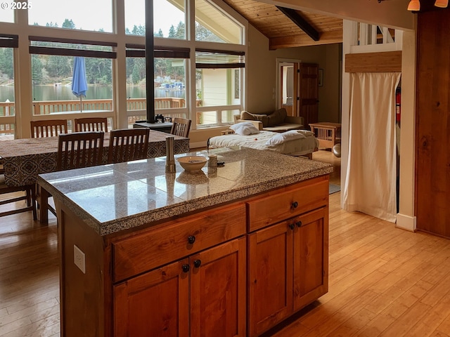 kitchen with light wood-type flooring, vaulted ceiling with beams, and wood ceiling