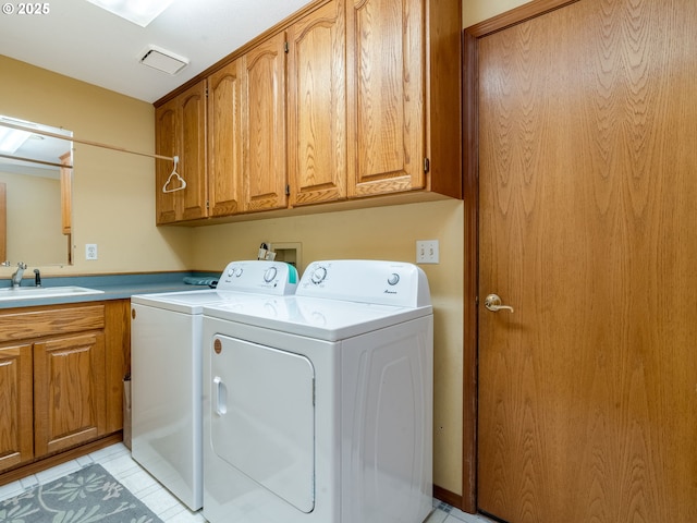 clothes washing area featuring sink, washer and dryer, and cabinets