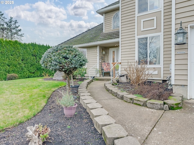 doorway to property featuring a lawn