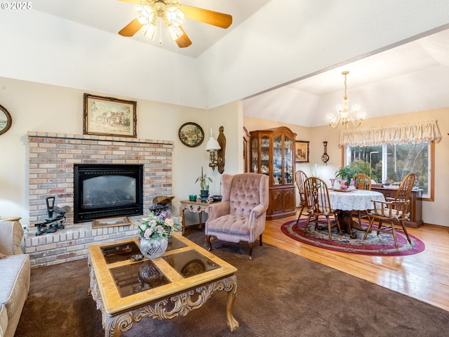 living room featuring hardwood / wood-style floors, vaulted ceiling, a raised ceiling, and a fireplace