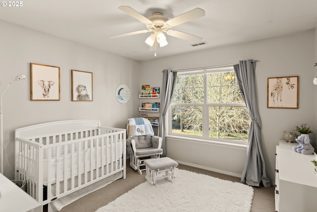 bedroom featuring carpet floors, a crib, and ceiling fan