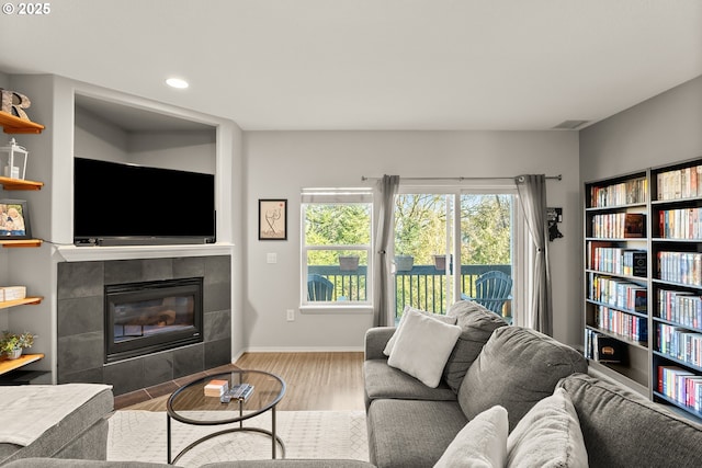 living room featuring a tiled fireplace and hardwood / wood-style floors