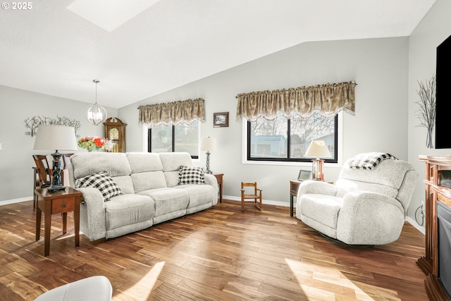 living room with a fireplace, lofted ceiling with skylight, and hardwood / wood-style floors