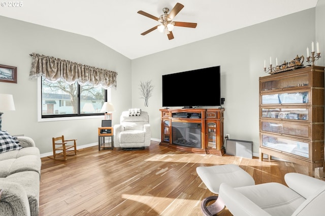 living room with ceiling fan, lofted ceiling, a fireplace, and hardwood / wood-style floors