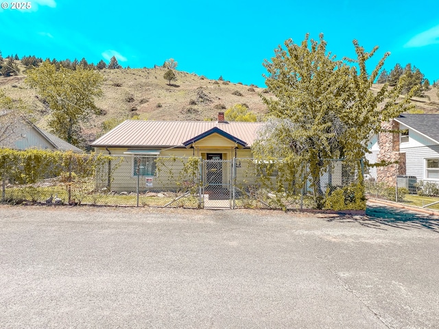 413 SW Brent Dr, John Day, OR 97845 - view of front facade featuring a fenced front yard, a gate, and a chimney